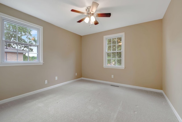 empty room featuring ceiling fan and light carpet