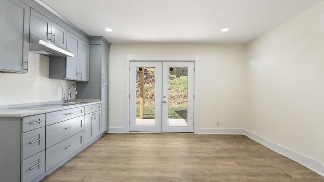 doorway with light hardwood / wood-style floors, french doors, and sink