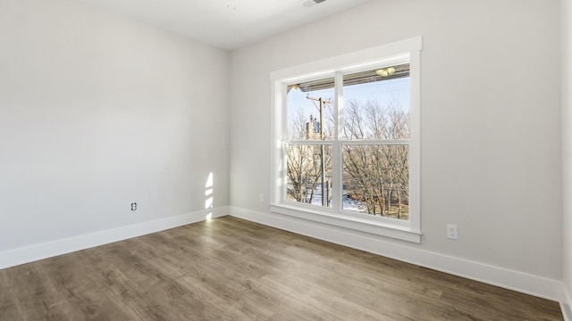 spare room with a healthy amount of sunlight and hardwood / wood-style flooring