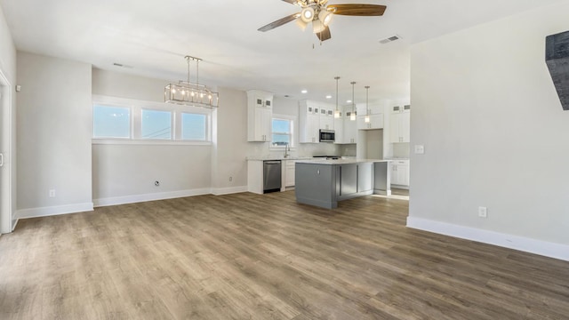 unfurnished living room with ceiling fan, sink, and hardwood / wood-style flooring