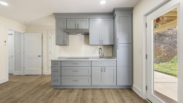 kitchen with sink, gray cabinetry, black electric cooktop, and light hardwood / wood-style flooring