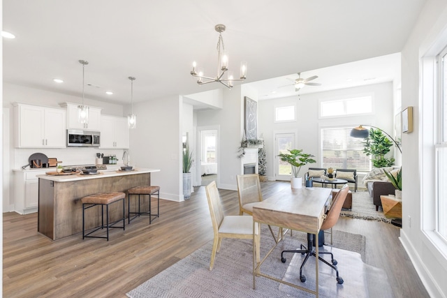 interior space with recessed lighting, wood finished floors, a ceiling fan, and baseboards