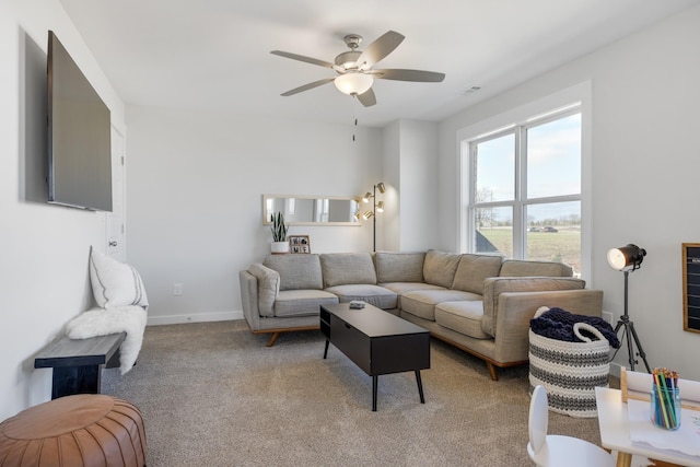 living room with light carpet, baseboards, and a ceiling fan