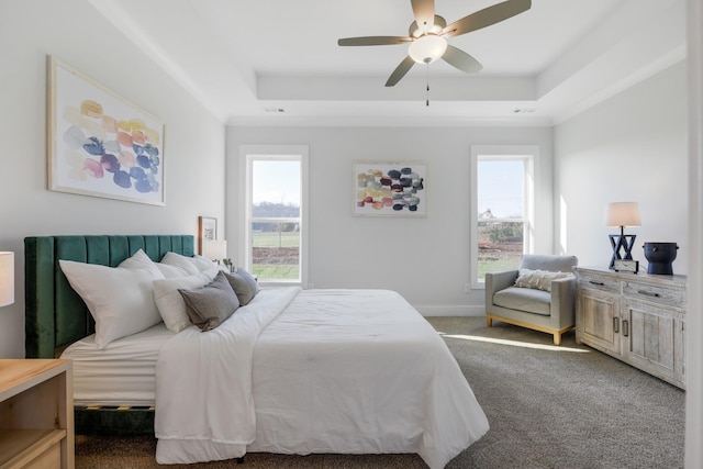 bedroom with carpet floors, a tray ceiling, a ceiling fan, and baseboards