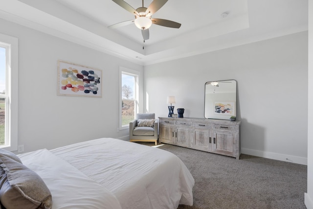 bedroom with carpet floors, baseboards, a raised ceiling, and a ceiling fan