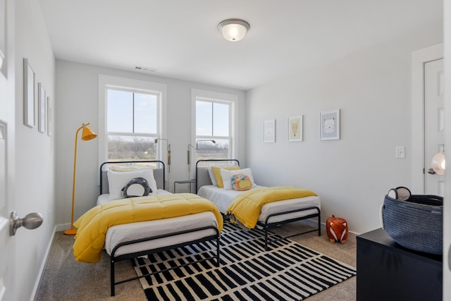 carpeted bedroom with visible vents and baseboards