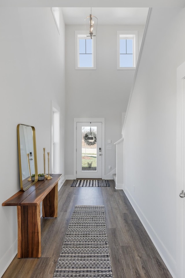 entryway featuring dark wood-style floors, baseboards, stairway, and a chandelier