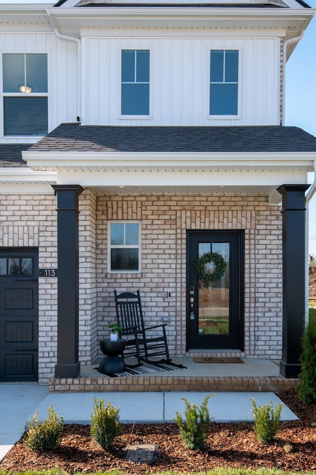 doorway to property with covered porch and a garage