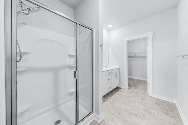 bathroom with a shower with shower door and vanity