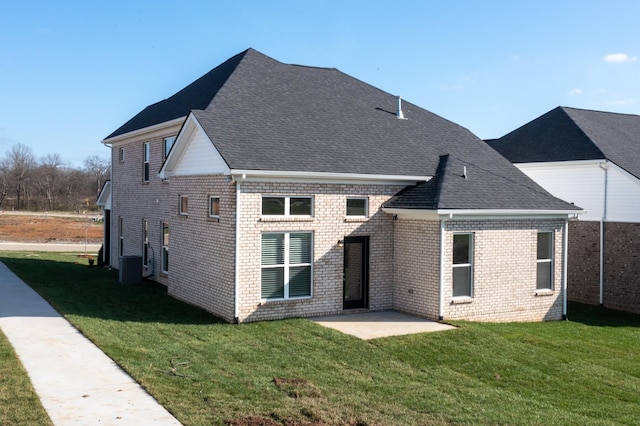 back of property with central air condition unit, a lawn, and a patio