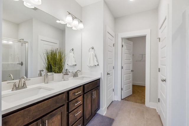 bathroom featuring a shower with shower door, vanity, and tile patterned flooring