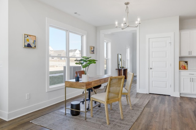 dining area with an inviting chandelier and dark hardwood / wood-style floors