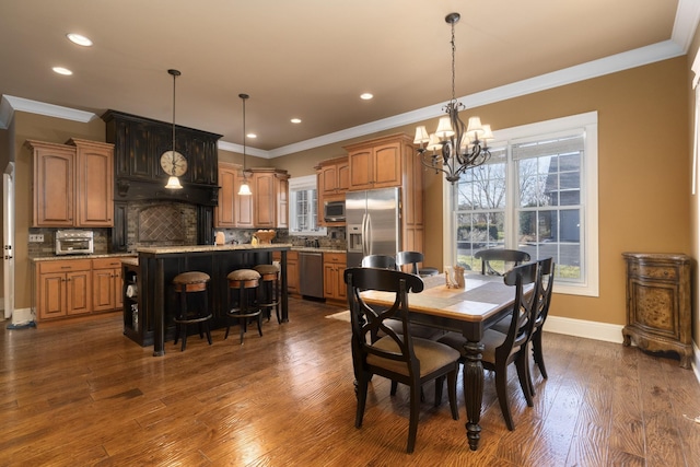 dining area with a notable chandelier, dark hardwood / wood-style flooring, and ornamental molding