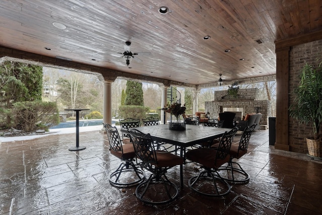 view of patio with ceiling fan and an outdoor stone fireplace