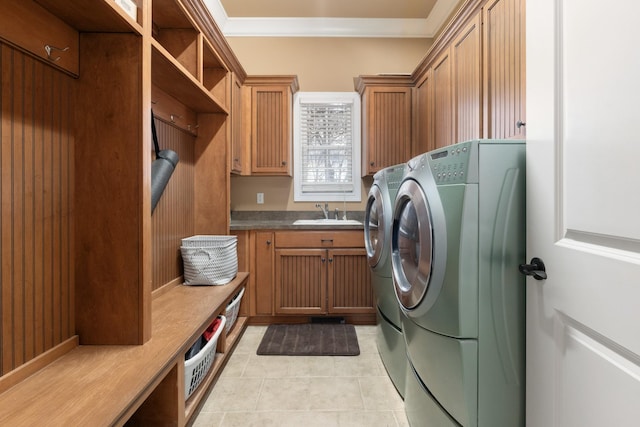 laundry room with light tile patterned floors, washer and dryer, cabinets, crown molding, and sink