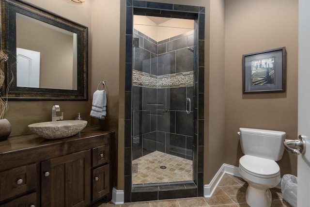 bathroom featuring toilet, tile patterned floors, an enclosed shower, and vanity