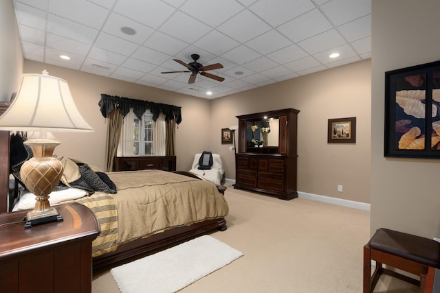 carpeted bedroom with ceiling fan and a paneled ceiling