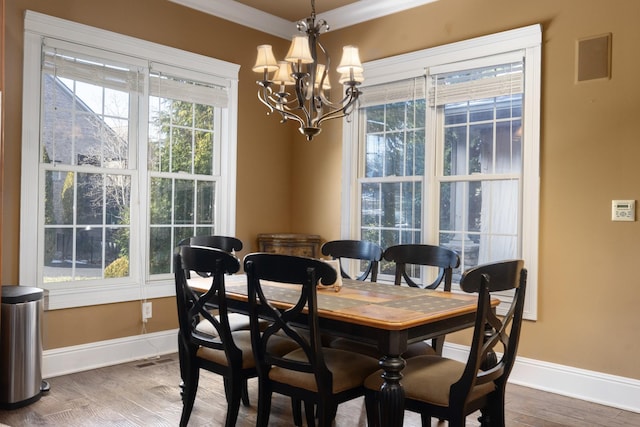 dining space featuring a chandelier, ornamental molding, and hardwood / wood-style floors