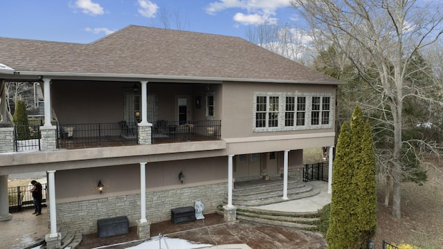 rear view of property featuring a patio area and a balcony