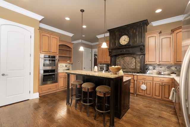 kitchen featuring decorative light fixtures, backsplash, a center island, a breakfast bar area, and stainless steel appliances