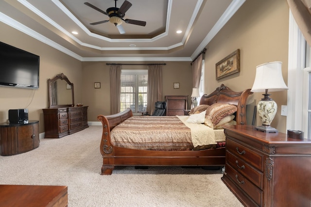 carpeted bedroom featuring a raised ceiling, ceiling fan, and ornamental molding