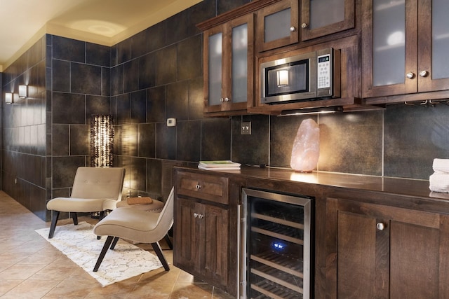 bar with light tile patterned floors, tile walls, beverage cooler, and dark brown cabinetry