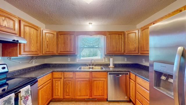 kitchen featuring a textured ceiling, stainless steel appliances, and sink