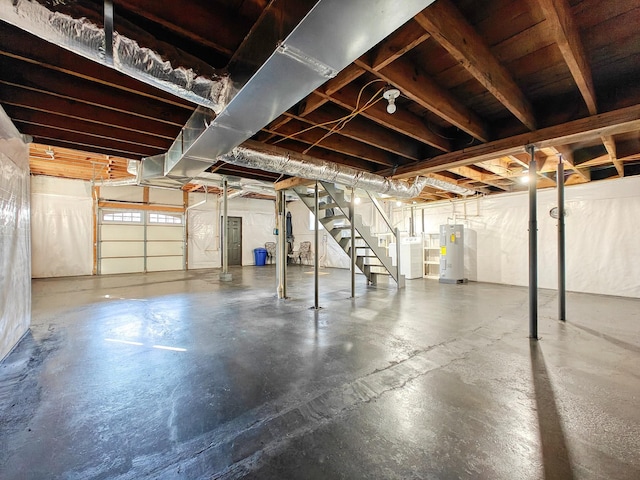 basement featuring electric water heater and washer / clothes dryer