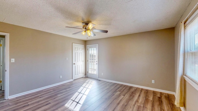 unfurnished room featuring ceiling fan, a textured ceiling, and light hardwood / wood-style flooring