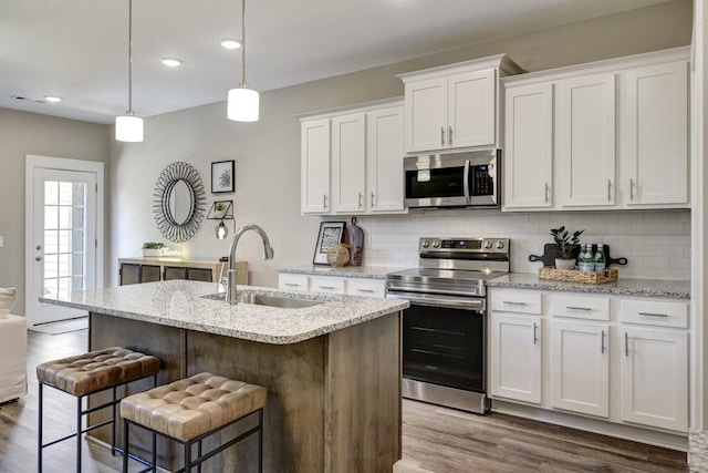 kitchen with appliances with stainless steel finishes, white cabinetry, and sink