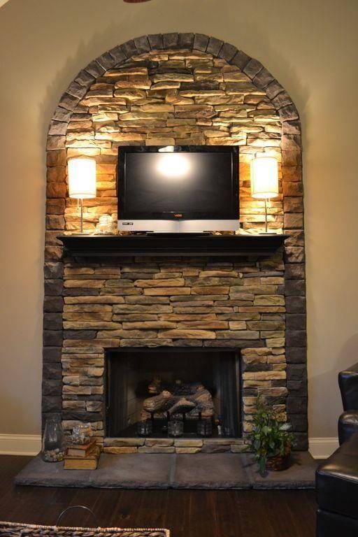 details with hardwood / wood-style floors and a stone fireplace