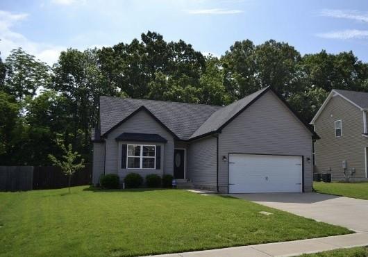 view of front of house featuring a front yard, cooling unit, and a garage