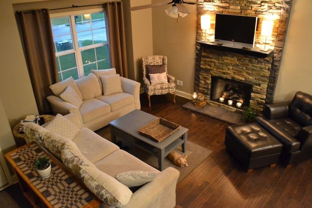 living room featuring hardwood / wood-style flooring, ceiling fan, and a fireplace