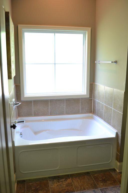 bathroom featuring a tub and a wealth of natural light