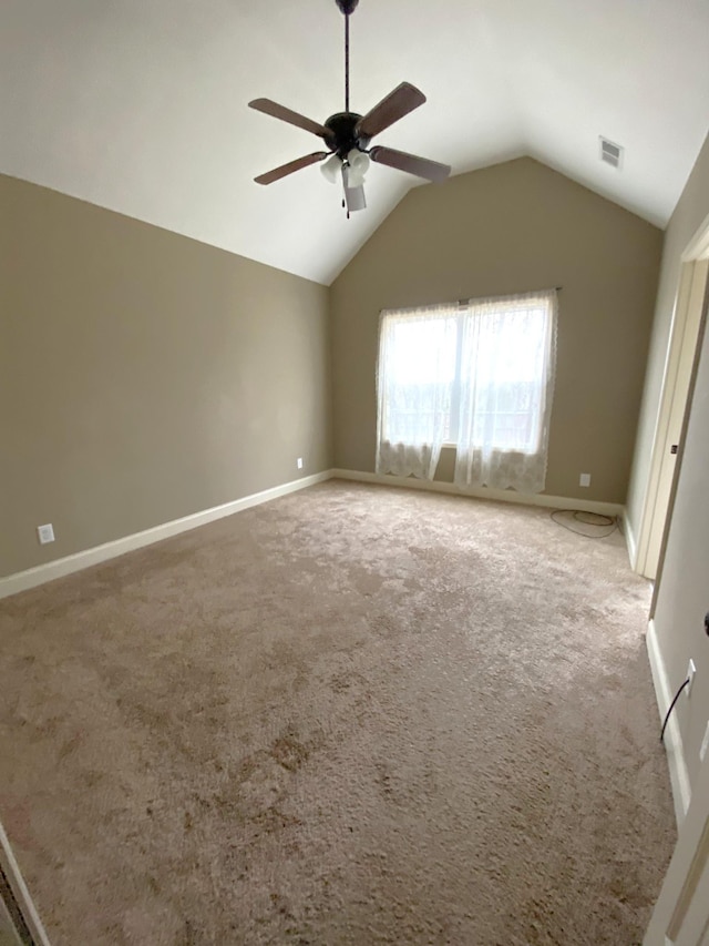 spare room featuring carpet, vaulted ceiling, and ceiling fan