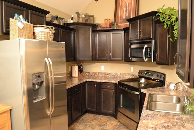 kitchen with light stone countertops, sink, stainless steel appliances, and dark brown cabinets