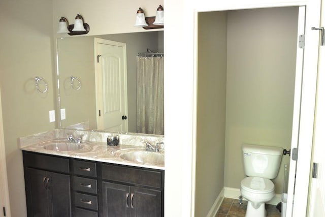 bathroom with toilet, tile patterned floors, and vanity