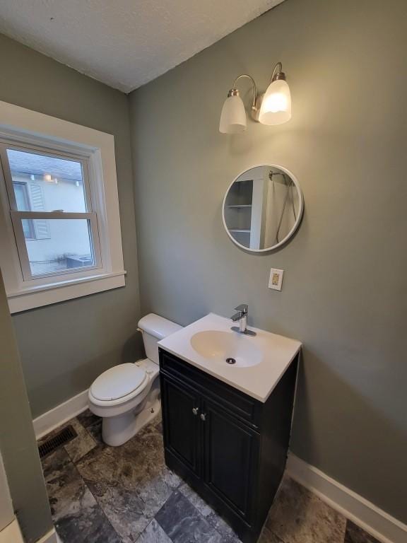 bathroom featuring toilet and vanity