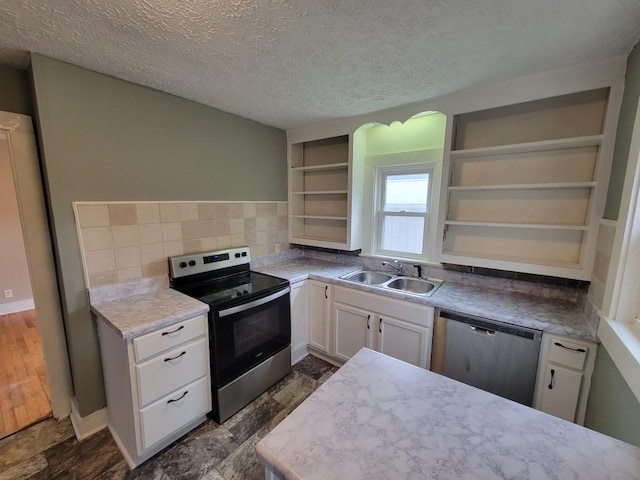 kitchen with a textured ceiling, stainless steel appliances, white cabinetry, and sink