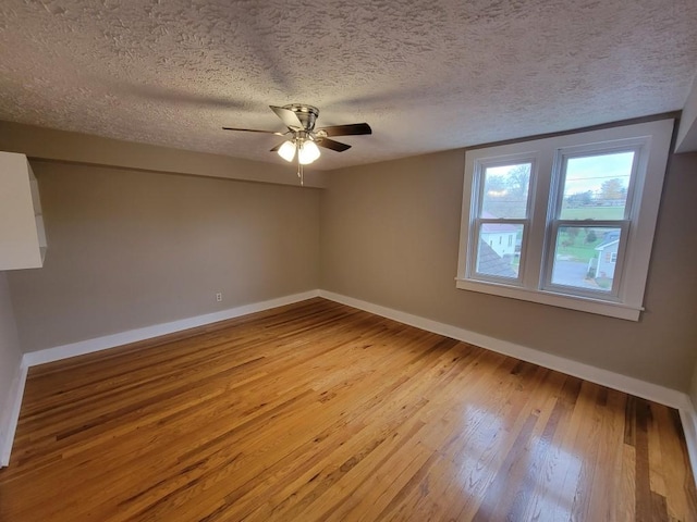 spare room with ceiling fan, a textured ceiling, and light hardwood / wood-style floors