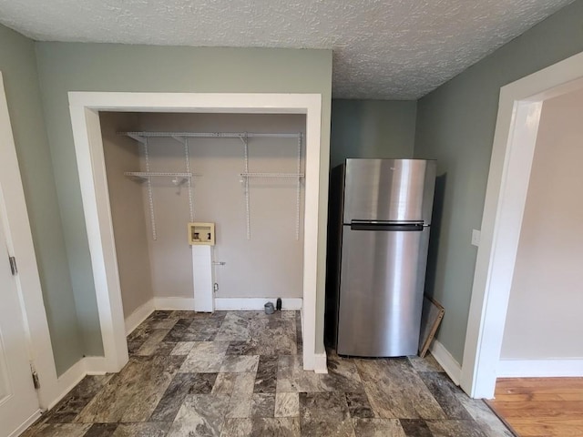 clothes washing area featuring a textured ceiling and hookup for a washing machine