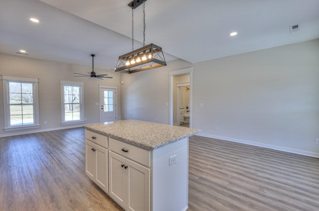 kitchen with ceiling fan, light hardwood / wood-style floors, a center island, pendant lighting, and white cabinetry