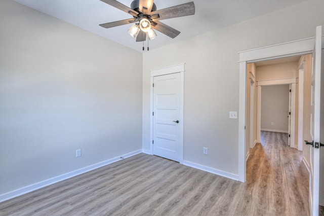 unfurnished bedroom with ceiling fan, a closet, and light wood-type flooring