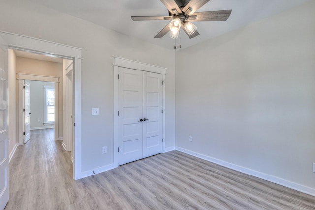 unfurnished bedroom featuring ceiling fan, a closet, and light hardwood / wood-style flooring