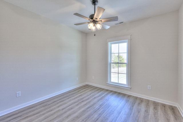 empty room with ceiling fan and light hardwood / wood-style floors