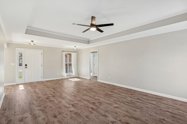 spare room featuring crown molding, ceiling fan, dark hardwood / wood-style floors, and a tray ceiling