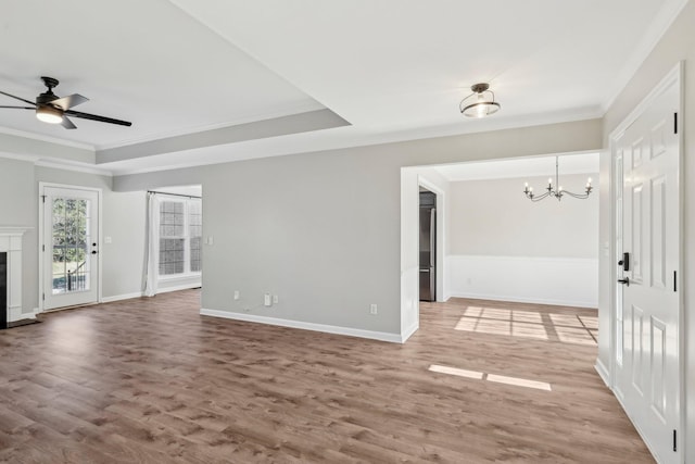 unfurnished living room featuring hardwood / wood-style floors, ornamental molding, and a raised ceiling