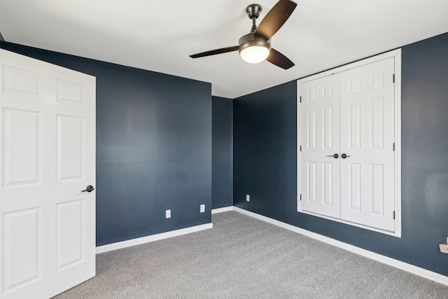 unfurnished bedroom featuring ceiling fan, a closet, and carpet