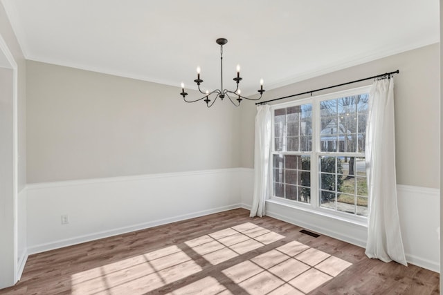 unfurnished dining area with light wood-type flooring and a notable chandelier