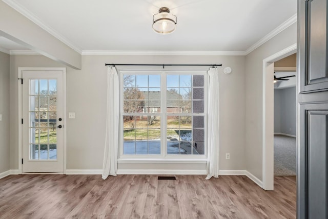 doorway to outside with ceiling fan, a healthy amount of sunlight, light wood-type flooring, and ornamental molding